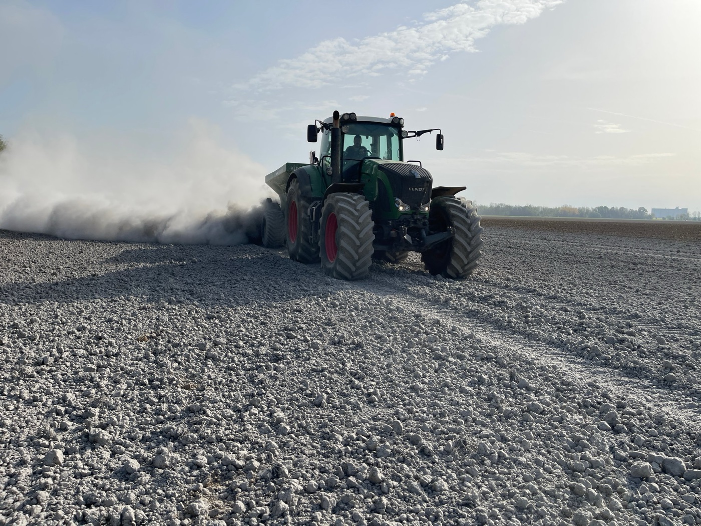 Fendt tractor spreading finely milled basalt dust across cropland